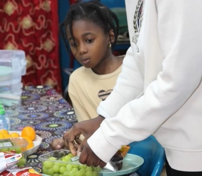 Child looking at snacks table during a community party